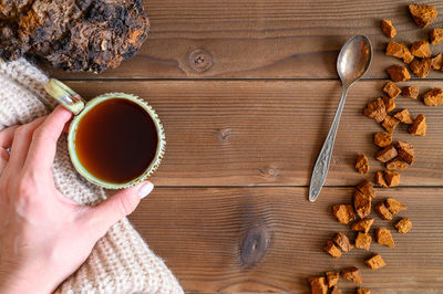 High angle view of hand holding coffee cup