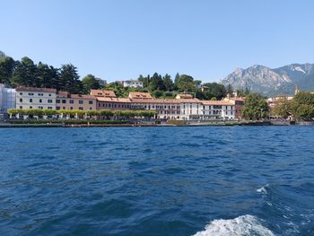 Scenic view of sea by buildings against clear sky
