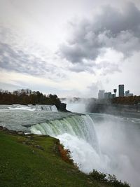 View of waterfall against cloudy sky