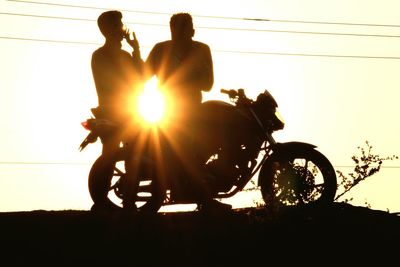 Silhouette people against sky during sunset