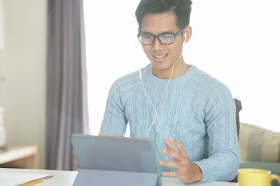 Smiling young man using mobile phone