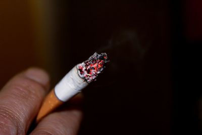 Close-up of hand holding cigarette