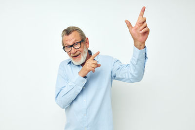 Portrait of senior man gesturing against white background