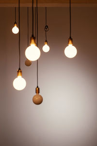 Low angle view of illuminated pendant lights hanging from ceiling