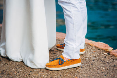 Low section of man standing on shore