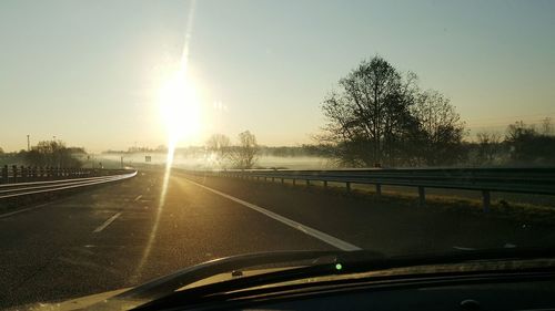 Road passing through sunset