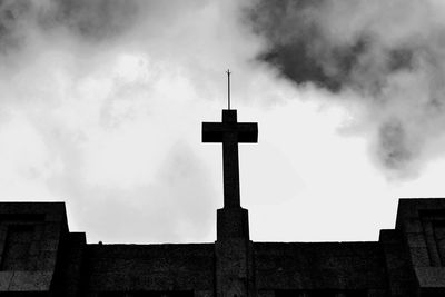 Low angle view of cross on building against sky