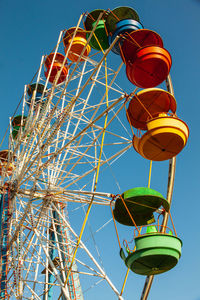 Colorful booths of the ferris wheel on blue sky background