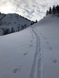 Snow covered land against sky