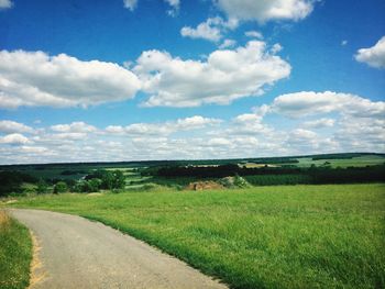 Scenic view of field against cloudy sky