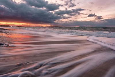 Scenic view of beach against sky during sunset