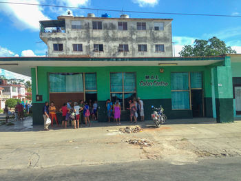 People on street against buildings in city