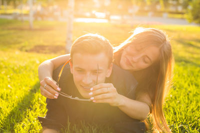 Portrait of smiling girl holding plant on field