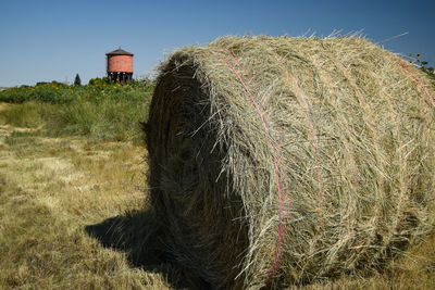 Hay bales on field against sky