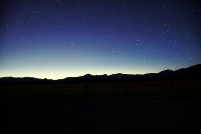 Silhouette landscape against clear sky at night