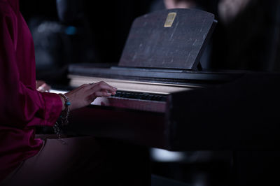 Midsection of man playing piano