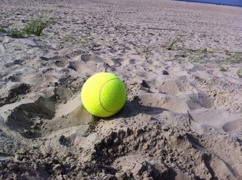 Tennis ball at sandy beach