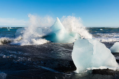 Water splashing in sea against sky