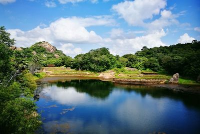 Scenic view of river by trees against sky