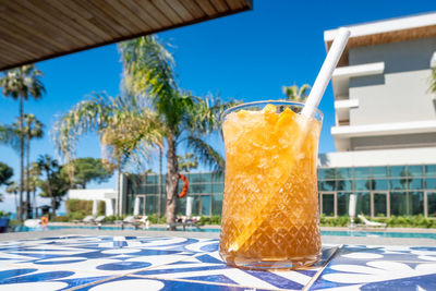 Fresh alcoholic cocktail with ice in glass on swimming pool. hard strong drink on sunlight 