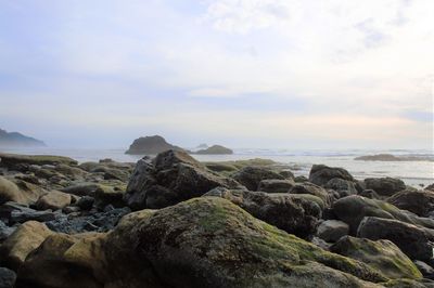 Rocks on beach against sky