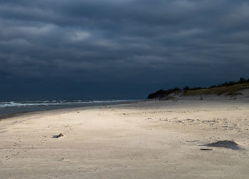 Scenic view of beach against cloudy sky