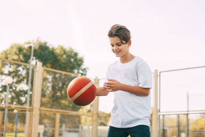 Boy playing with basketball at court