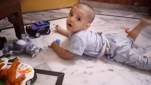 High angle portrait of cute baby boy lying on bed at home