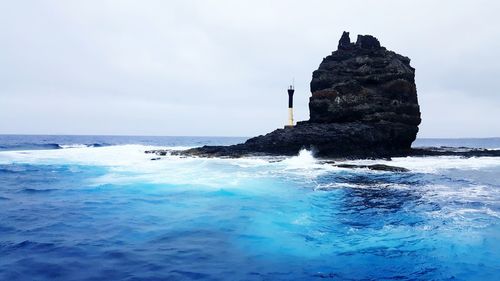 Rocks in sea against sky