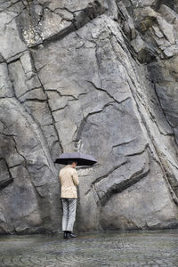 Rear view of man standing on rock