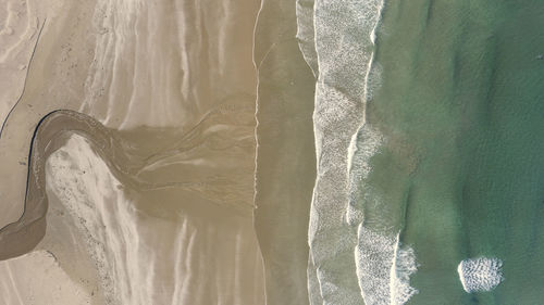 High angle view of water splashing on beach