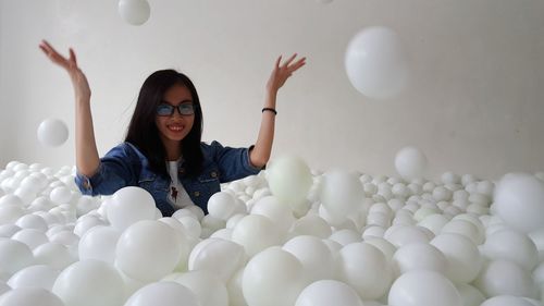 Portrait of smiling young woman with balloons