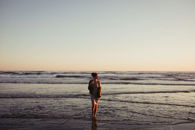 Beautiful woman on long beach at sunset in tofino