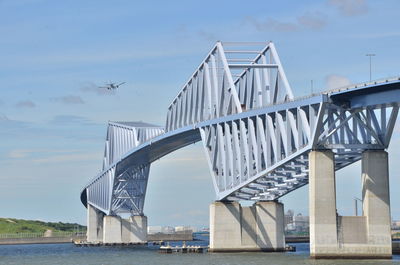 Bridge over river in city against sky