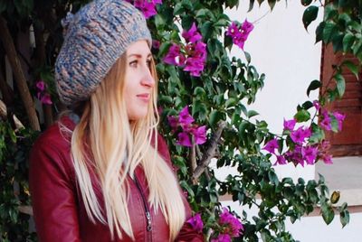 Portrait of beautiful young woman looking at flowering plants