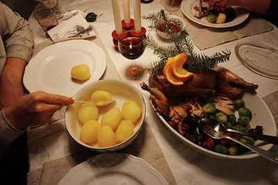 Cropped hands having boiled potatoes on table at home