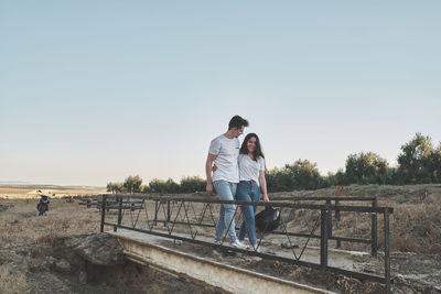 Man and woman on umbrella against clear sky