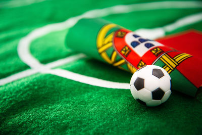 Close-up of figurine soccer ball with flag on playing field