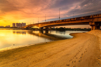 A long exposure picture of beautiful burning sunset under the bridge