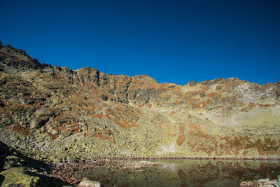 Scenic view of rocky mountains against clear blue sky