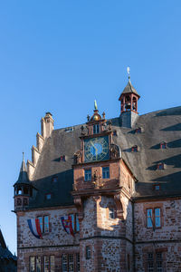 Low angle view of old building against clear blue sky