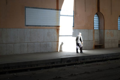 Rear view of woman walking in corridor of building