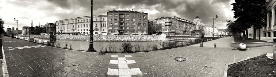 Buildings in city against cloudy sky