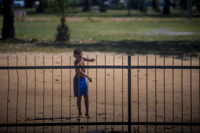 Rear view of woman standing by railing