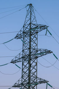 Low angle view of electricity pylon against clear sky