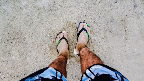 Low section of man standing at shore