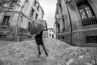 Rear view of woman walking on street in city