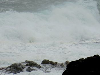 Scenic view of waves against sky during winter