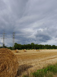 Hay bales on field against sky