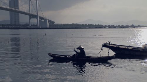 Man on bridge over river against sky